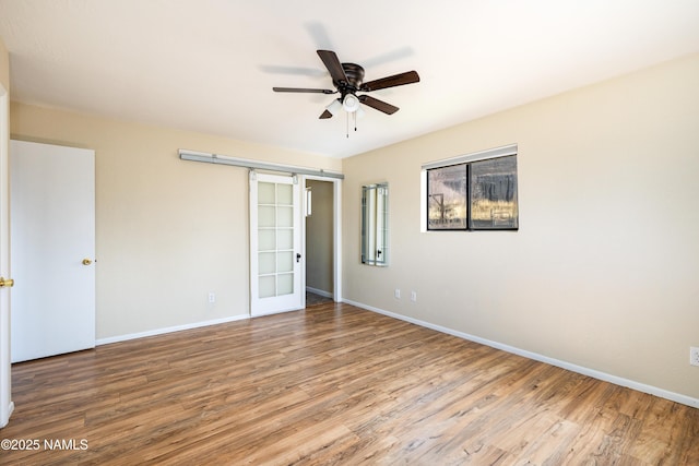 unfurnished bedroom featuring ceiling fan, baseboards, and wood finished floors