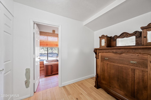 bedroom with ensuite bath and light hardwood / wood-style floors