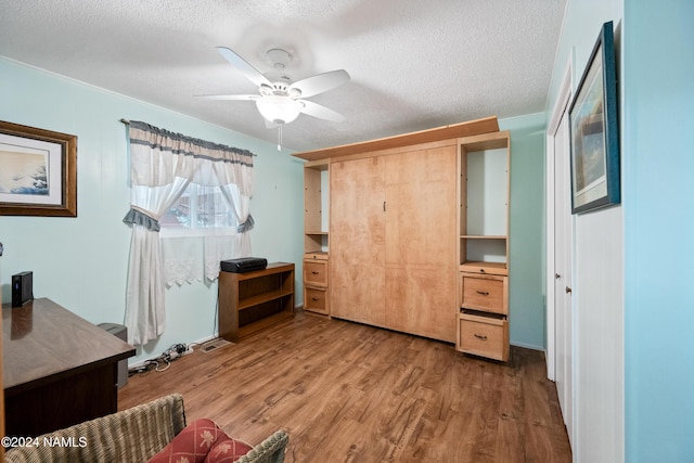 interior space with ceiling fan, hardwood / wood-style floors, and a textured ceiling