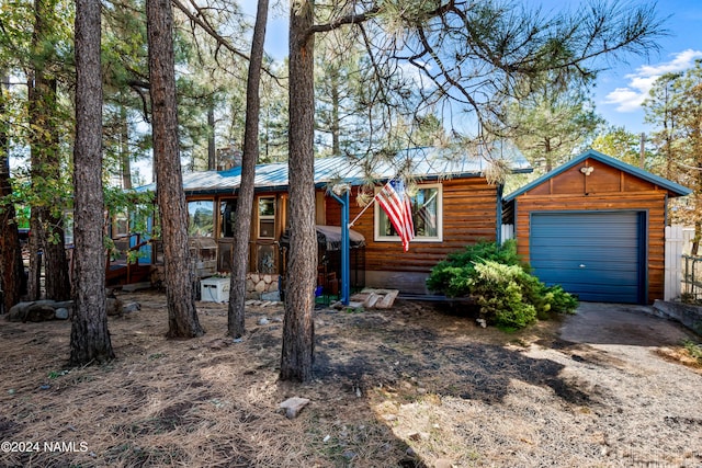 cabin featuring a garage and an outdoor structure