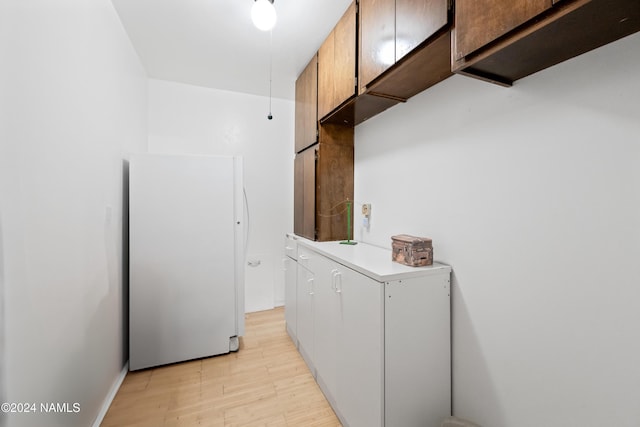 laundry area with light wood-type flooring