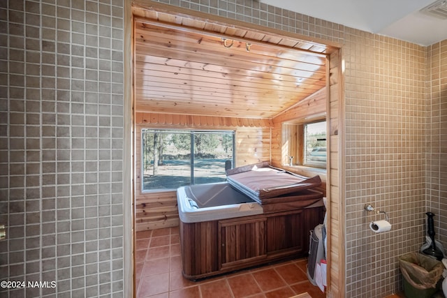 bathroom with vaulted ceiling, wooden ceiling, tile walls, and tile patterned floors