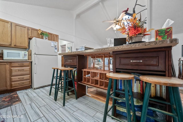 kitchen with lofted ceiling with beams, ceiling fan, and white appliances