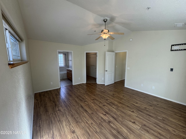 unfurnished room with vaulted ceiling, dark hardwood / wood-style floors, and ceiling fan