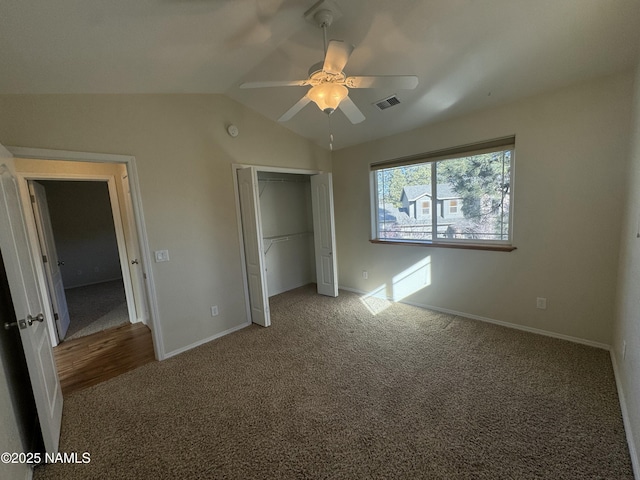 unfurnished bedroom with lofted ceiling, carpet floors, ceiling fan, and a closet