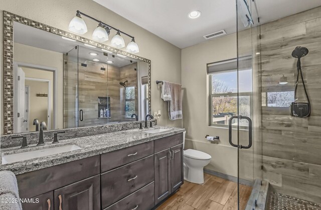 8841 E Rolling Thunder Dr, Flagstaff, AZ 86004 - full bathroom with a shower stall, double vanity, wood finished floors, toilet, and recessed lighting