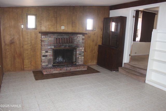322 W Mahoney St, Winslow, AZ 86047 - unfurnished living room with wood walls, a fireplace, light tile patterned flooring, and stairs