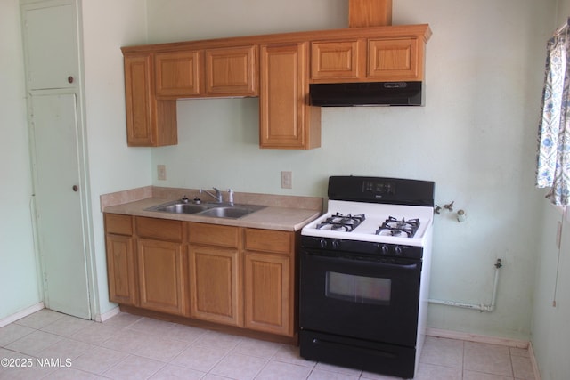 322 W Mahoney St, Winslow, AZ 86047 - kitchen with gas stove, under cabinet range hood, a sink, light countertops, and brown cabinetry