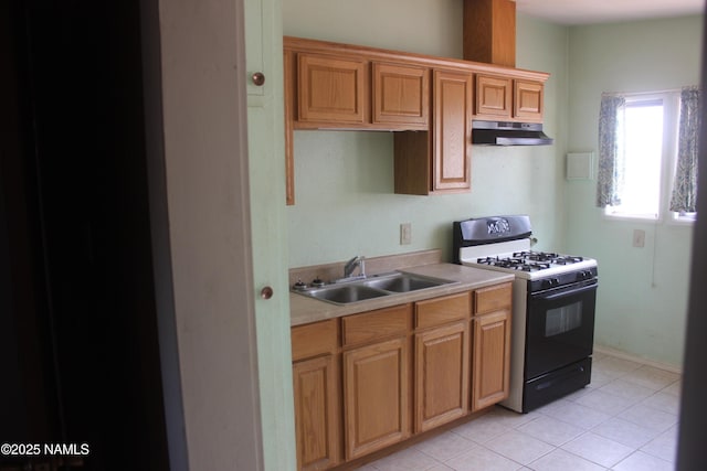 322 W Mahoney St, Winslow, AZ 86047 - kitchen with range with gas stovetop, under cabinet range hood, a sink, light countertops, and light tile patterned floors
