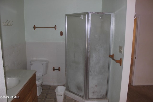 322 W Mahoney St, Winslow, AZ 86047 - bathroom with toilet, a shower stall, vanity, tile walls, and wainscoting