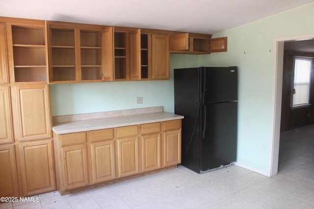 322 W Mahoney St, Winslow, AZ 86047 - kitchen with freestanding refrigerator, open shelves, light countertops, and light tile patterned flooring