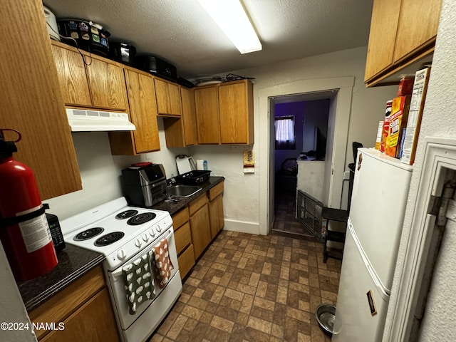 kitchen with sink, white appliances, and a textured ceiling