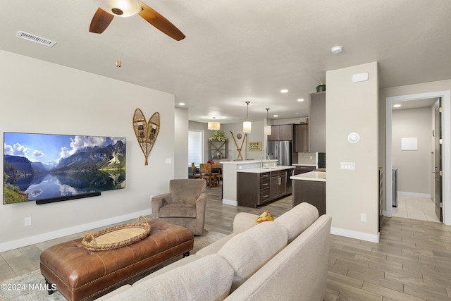 living room with ceiling fan and sink