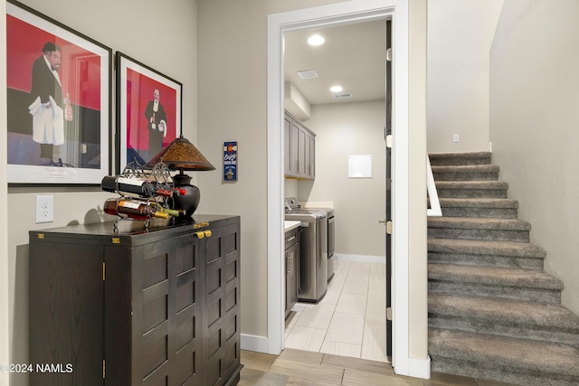 washroom with separate washer and dryer and cabinets