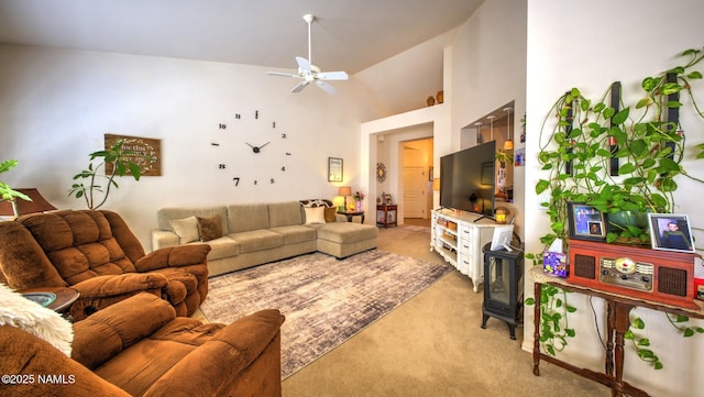 living area featuring ceiling fan, a high ceiling, and light colored carpet