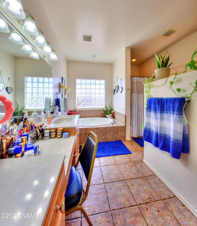 bathroom with tile patterned flooring, visible vents, a garden tub, and vanity