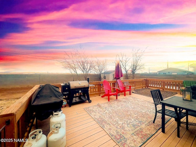 wooden terrace featuring a grill and fence