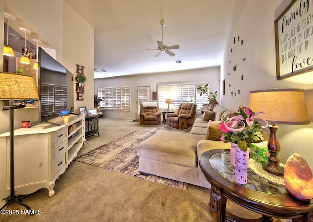 living room featuring carpet floors, visible vents, and ceiling fan