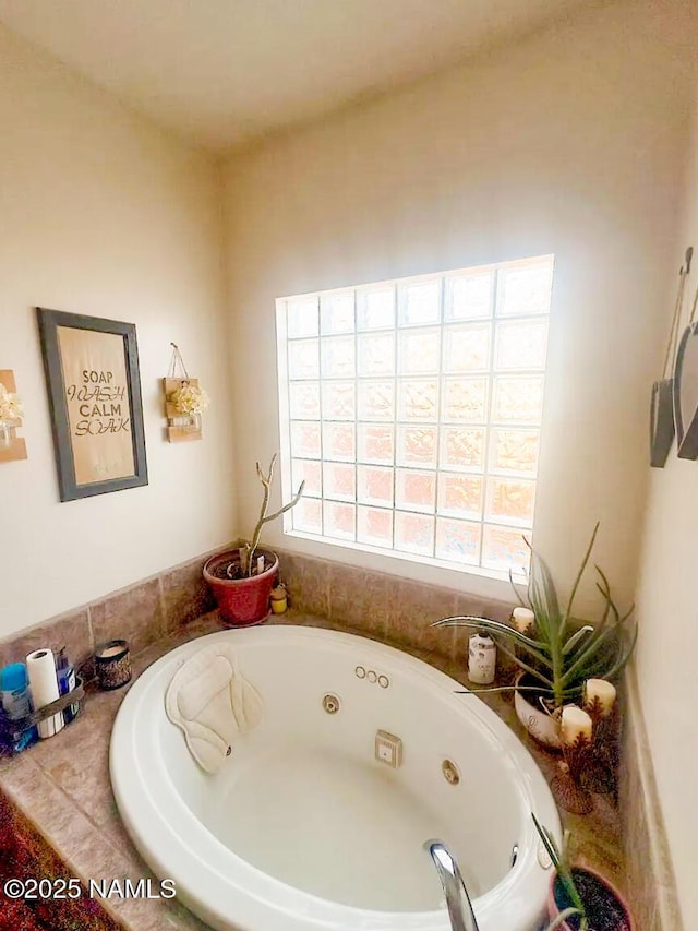 bathroom with a wealth of natural light and a whirlpool tub