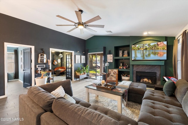 living room with light wood-type flooring, ceiling fan, and lofted ceiling