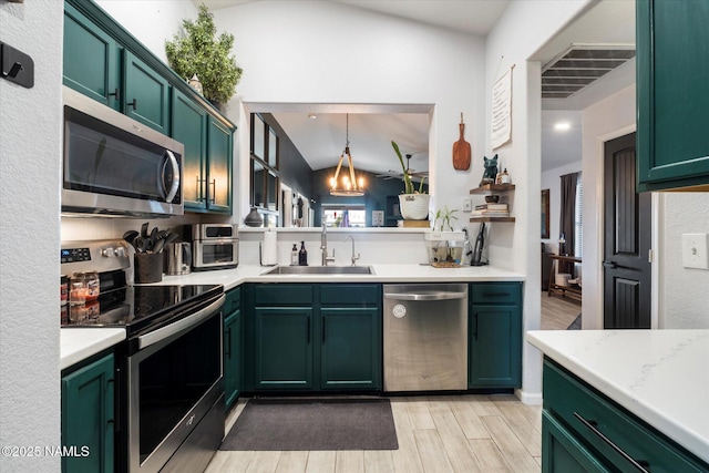 kitchen with light stone countertops, appliances with stainless steel finishes, sink, pendant lighting, and lofted ceiling