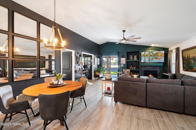 dining room with ceiling fan with notable chandelier and lofted ceiling