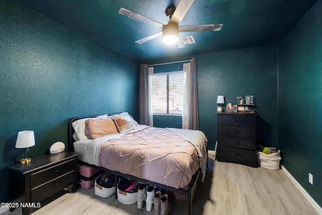 bedroom with light hardwood / wood-style flooring and ceiling fan