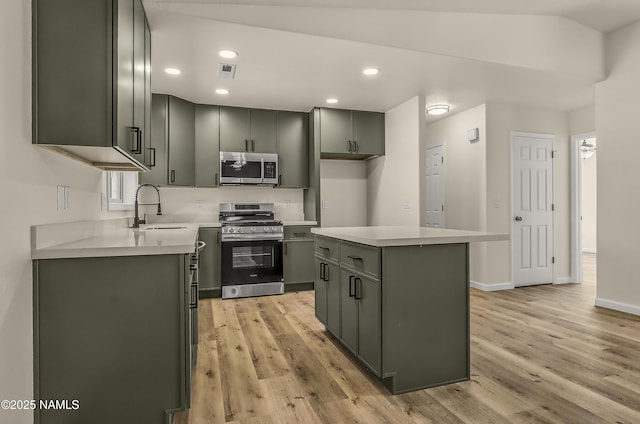 9835 Pioneer Valley Rd, Flagstaff, AZ 86004 - kitchen featuring appliances with stainless steel finishes, a sink, light wood finished floors, light countertops, and a center island