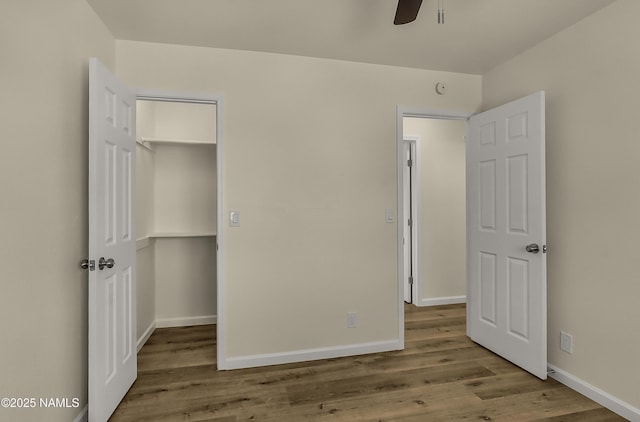 9835 Pioneer Valley Rd, Flagstaff, AZ 86004 - unfurnished bedroom with wood finished floors, a walk in closet, baseboards, and a closet