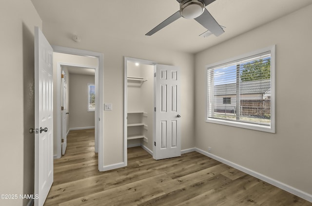 9835 Pioneer Valley Rd, Flagstaff, AZ 86004 - unfurnished bedroom with wood finished floors, baseboards, a ceiling fan, a walk in closet, and a closet