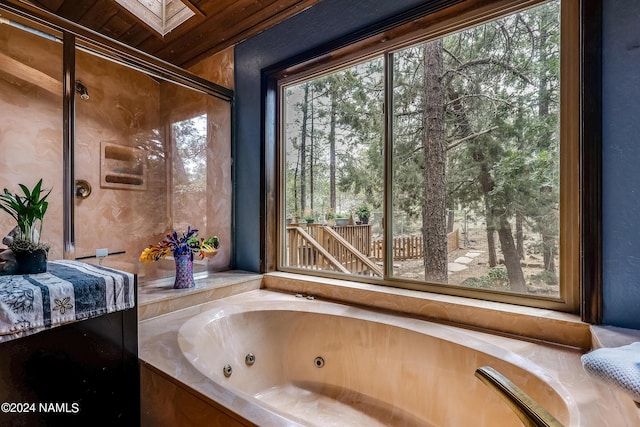 bathroom featuring a tub with jets and a skylight