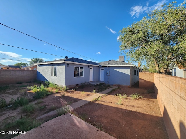 view of front facade with roof with shingles, crawl space, a fenced backyard, and stucco siding