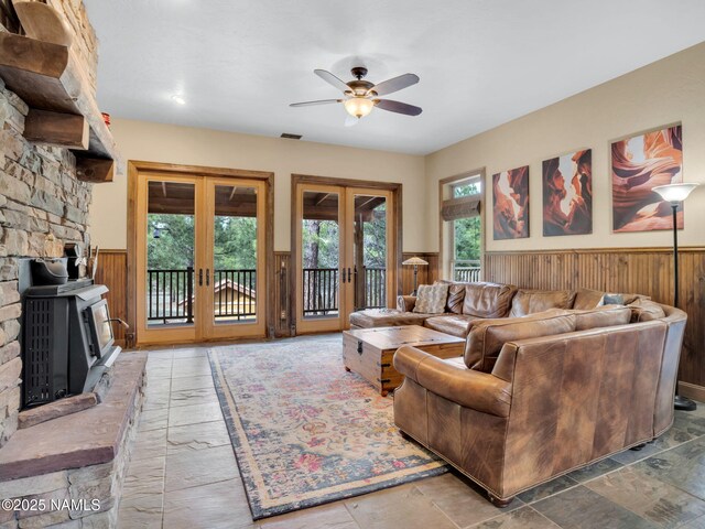284 E Foothill Trl, Williams, AZ 86046 - living room featuring visible vents, wainscoting, ceiling fan, wooden walls, and french doors