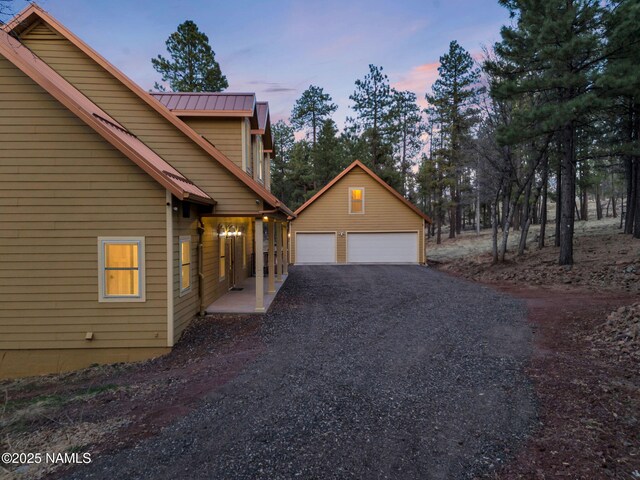284 E Foothill Trl, Williams, AZ 86046 - property exterior at dusk featuring an outbuilding, metal roof, and a garage