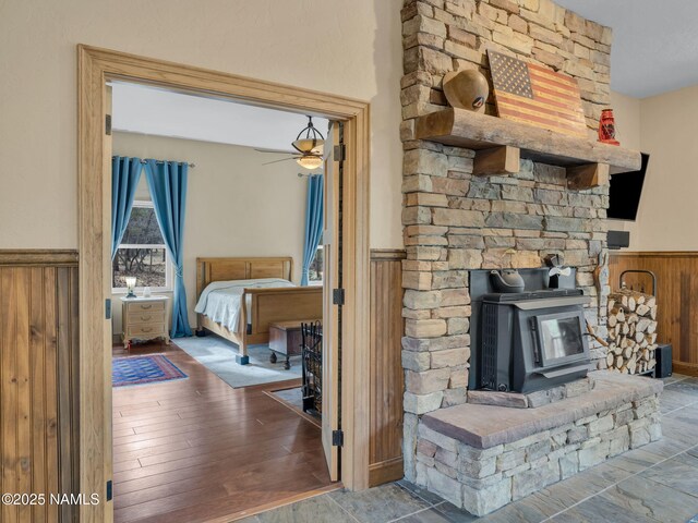 284 E Foothill Trl, Williams, AZ 86046 - interior details with ceiling fan, a wood stove, and a wainscoted wall