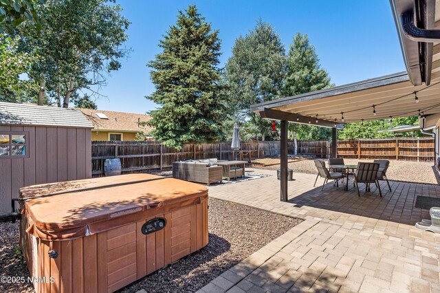 3425 W Mountain Dr, Flagstaff, AZ 86001 - fenced backyard featuring a hot tub, outdoor dining space, a patio area, and a storage unit