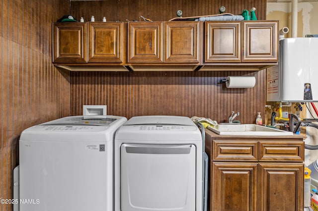 3425 W Mountain Dr, Flagstaff, AZ 86001 - washroom featuring washing machine and clothes dryer, tankless water heater, wood walls, and cabinet space