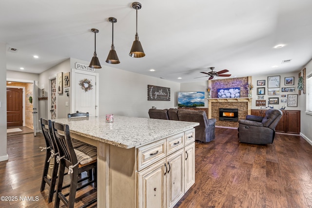 3425 W Mountain Dr, Flagstaff, AZ 86001 - kitchen featuring a ceiling fan, a large fireplace, dark wood-style flooring, recessed lighting, and light stone counters