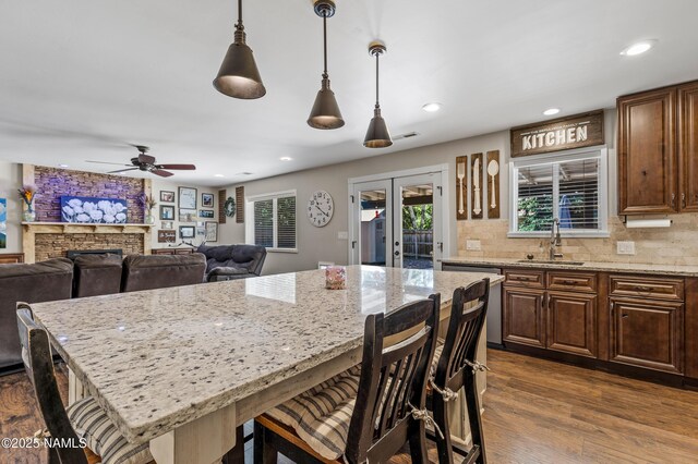 3425 W Mountain Dr, Flagstaff, AZ 86001 - kitchen featuring stainless steel dishwasher, a breakfast bar area, ceiling fan, a center island, and light stone counters