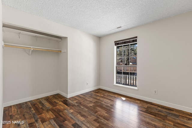 1536 N Foxglenn St, Flagstaff, AZ 86004 - unfurnished bedroom featuring a textured ceiling, dark wood-style flooring, a closet, and baseboards