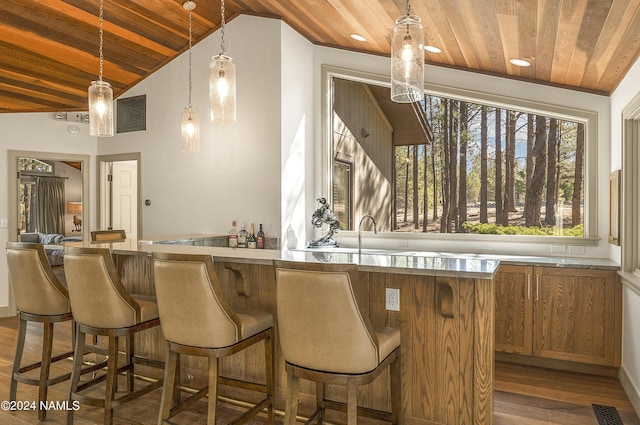 bar featuring wood ceiling, hardwood / wood-style floors, pendant lighting, and lofted ceiling