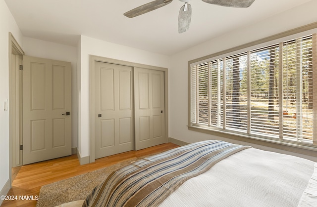 bedroom with a closet, ceiling fan, and light wood-type flooring