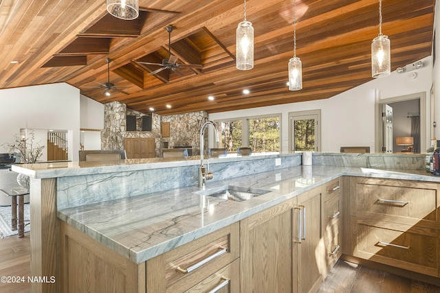 kitchen with light stone countertops, dark hardwood / wood-style flooring, sink, lofted ceiling with beams, and wooden ceiling