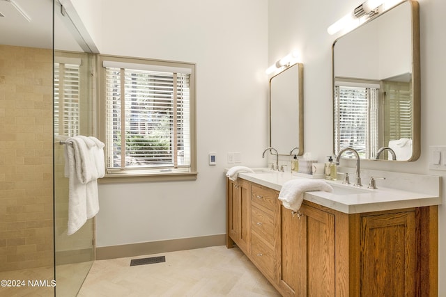 bathroom featuring tiled shower, tile patterned flooring, and vanity