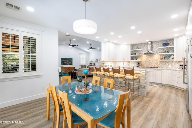 dining area featuring light wood-type flooring, lofted ceiling, and ceiling fan