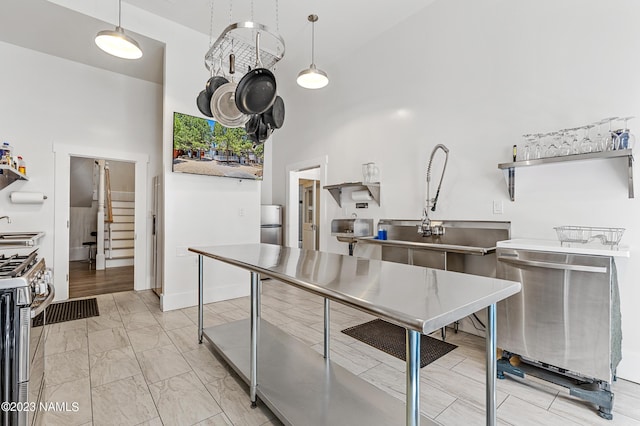 3380 E Lockett Rd, Flagstaff, AZ 86004 - kitchen with appliances with stainless steel finishes, a sink, a towering ceiling, light marble finish flooring, and stainless steel countertops