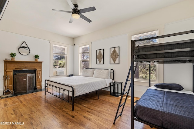 3380 E Lockett Rd, Flagstaff, AZ 86004 - bedroom with wood finished floors, multiple windows, a fireplace, and a ceiling fan
