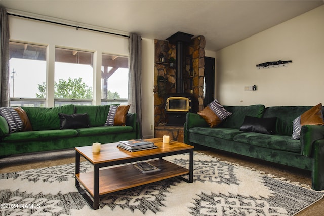 living area with lofted ceiling and a wood stove