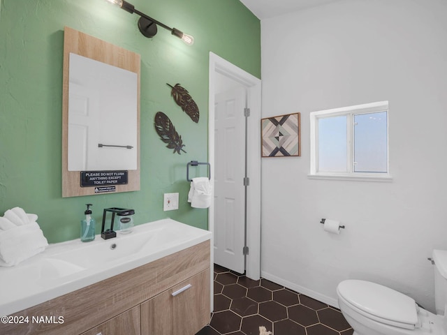 half bath featuring toilet, baseboards, and vanity