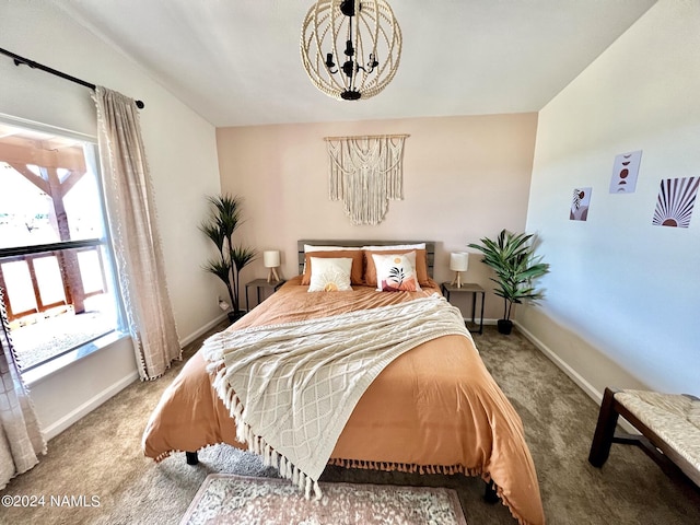 carpeted bedroom featuring a chandelier and baseboards